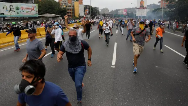 Manifestantes huyen de los gases.