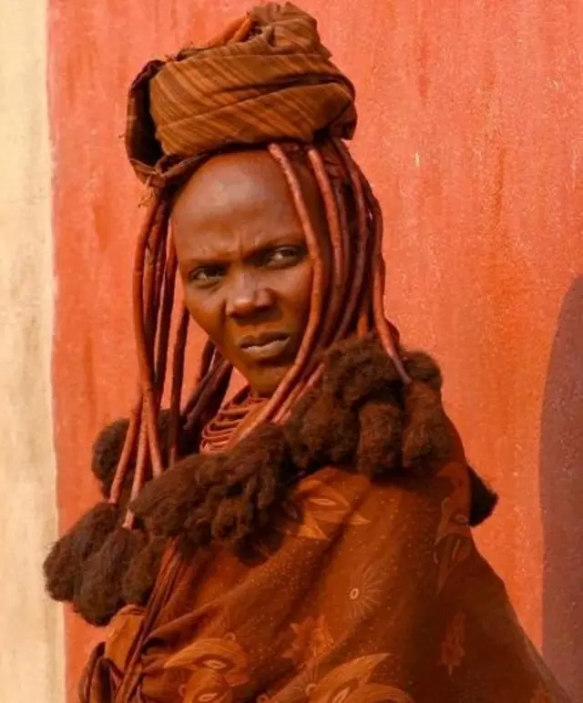 ওয়েইন রাথবোন: নামিবিয়ার হিমবা গোত্রের একজন নারী ওৎজিতে মিশ্রণ মাখিয়ে রেখেছেন, মাখন আর মাটি মিশিয়ে যা তৈরি করা হয়। এগুলো তার ত্বককে ভালো রাখতে সাাহায্য করে।