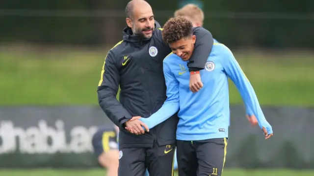Jadon Sancho junto a Pep Guardiola.
