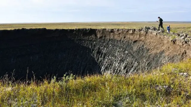 Imagem do cientista Evgeny Chuvilin analisando a bordaquote bwin serie auma das crateras, um grande buraco negro na tundra