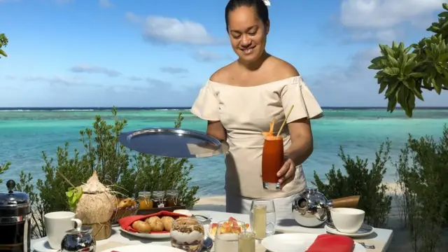 Garçonete servindo comida e bebidas no resort de luxo The Brando