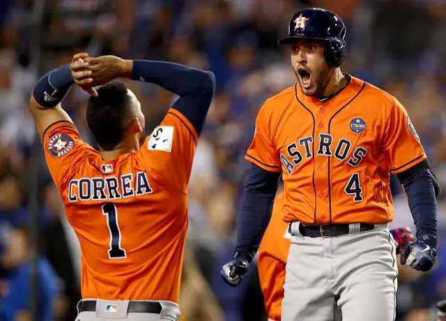 George Springer celebra con Carlos Correa una carrera de los Astros.