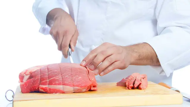 Кухар ріже м'ясо
