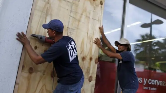 ชาย 2 คนนี้เร่งเสริมความแข็งแรงให้หน้าต่างห้างร้าน ก่อนเฮอร์ริเคนมาเรียจะพัดถล่มเปอร์โตริโก