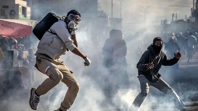 One protester wey wear gas mask jump to avoid teargas canister during fight-fight Malagasy security forces