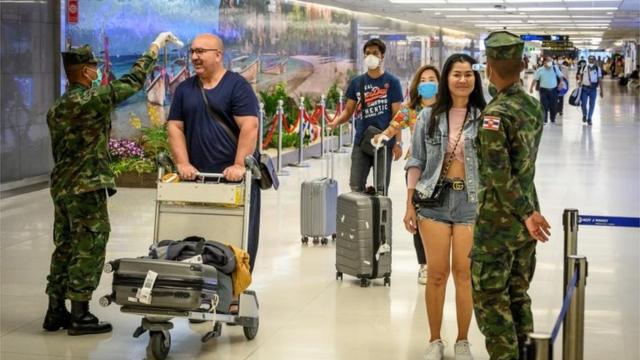 Thai soldiers take the temperatures of arriving passengers at Phuket International Airport