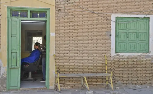 A barber serves a costumer in Nefta, Tunisia - Sunday 13 February 2022