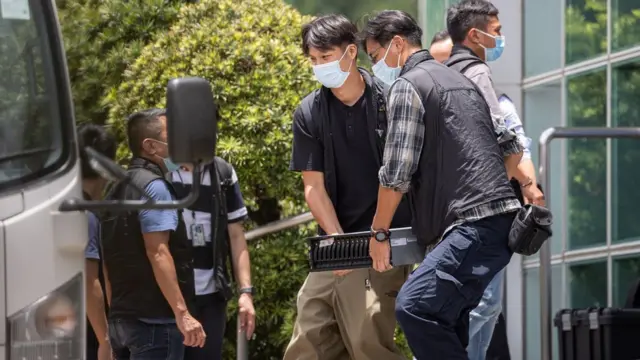 香港警察在将军澳壹传媒总部暨《苹果日报》报社大楼外把一台电脑主机抬上警车（17/6/2021）