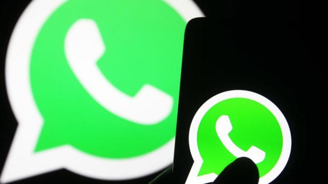 Logo do WhatsApp em tela de celular e projetado em tela maior atrás