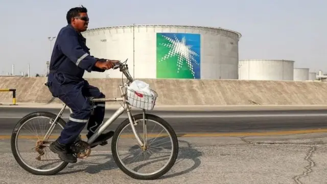 सऊदी कंपनी अरामको के सामने से जाता हुआ एक व्यक्ति