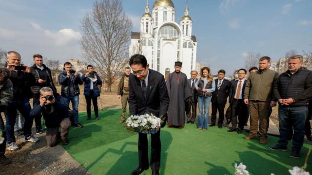 キーウ近郊ブチャで集団埋葬地に花を手向ける岸田首相（21日、ウクライナ・ブチャ）