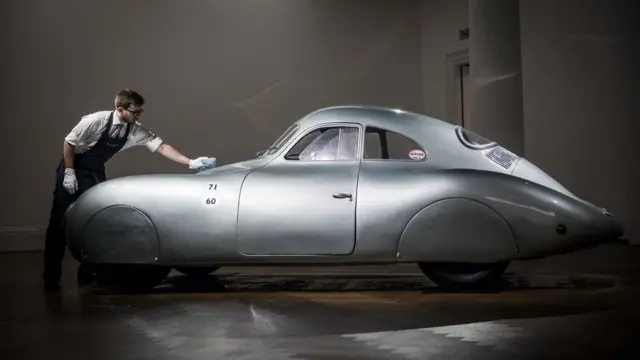 A man polishes a Porsche at Sotheby's