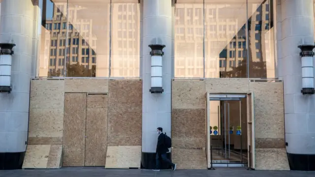 Una tienda en Nueva York con tablones de madera tapando sus vitrinas.
