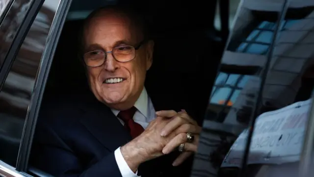 Mr Giuliani leaving the courthouse on Friday