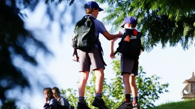 Старший хлопець тягне за руку молодшого