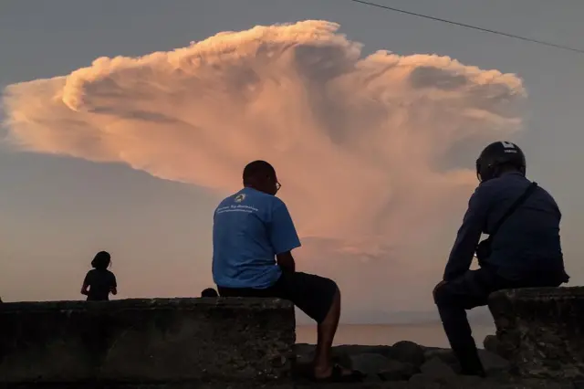 Warga melihat erupsi Gunung Lewotobi Laki-laki dari Pantai Wairotang, Kabupaten Sikka, Nusa Tenggara Timur, Selasa (17/06).
