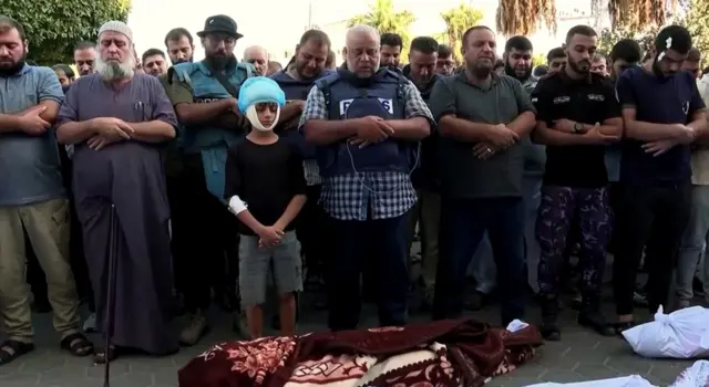 시신 앞에서 묵념하는 사람들의 모습