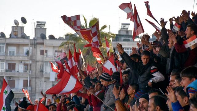 Los aficionados del Al-Ittihad ondean las banderas rojo y blanco, los colores de su equipo.