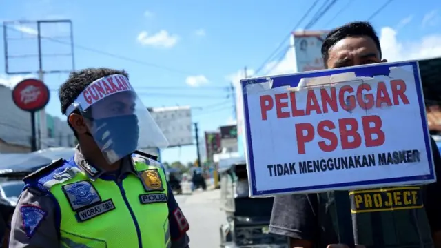 Warga memegang papan pelanggaran saat razia penguatan Pembatasan Sosial Berskala Besar (PSBB) di Kota Gorontalo, Gorontalo, Rabu (27/05). Kegiatan tersebut dilakukan untuk meningkatkan tingkat kedisiplinan masyarakat agar menerapkan protokol kesehatan sebagai upaya pencegahan COVID-19.