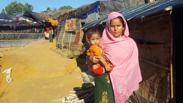 ঝুপড়ি ঘরের দরজায় ছোট্ট শিশু কোলে তরুণী বধূ সলেমা খাতুন।