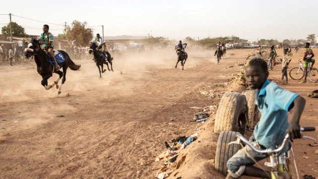 Un jeune garçon regarde une course de chevaux à Ouagadougou, au Burkina Faso - dimanche 30 janvier 2022.
