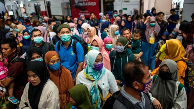 Indonesians wear masks at transport hub.