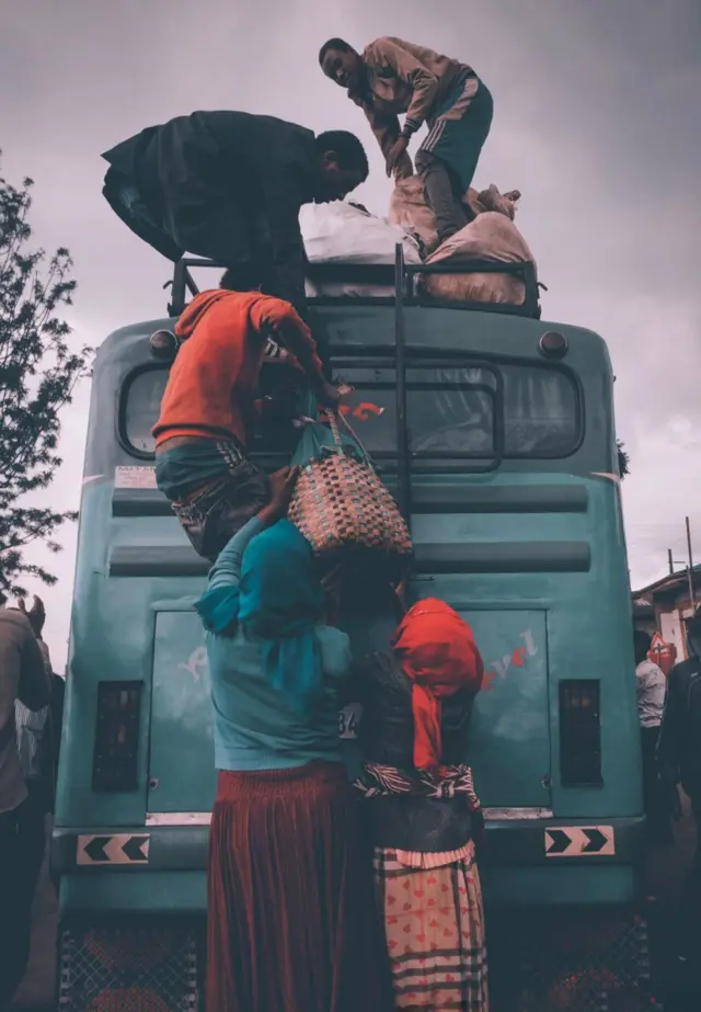 ሰዎች በተለምዶ ቅጥቅጥ የህዝብ ማመላለሻ የሚባለው መኪና ላይ እቃ ሲጭኑ።