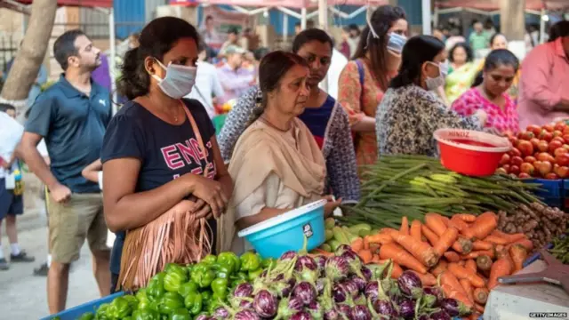 માસ્ક પહેરીને શાકભાજી ખરીદતાં મહિલા
