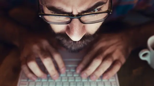 Una persona mirando muy de cerca su computador