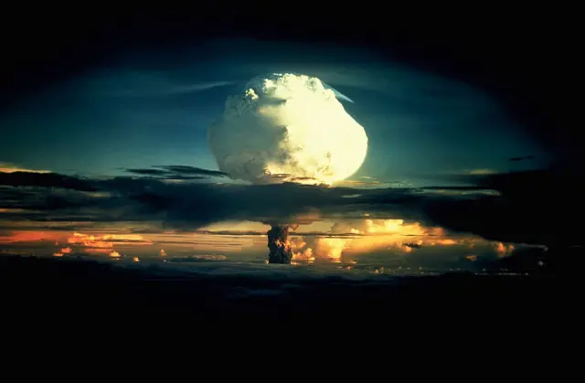 Un énorme champignon blanc, tacheté d'orange, traverse une couche de nuages pendant l'opération Ivy, le premier essai de la bombe à hydrogène, sur l'atoll d'Enewetak, dans les îles Marshall.