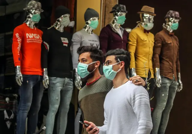 Palestinians wearing face masks
