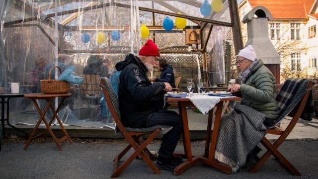 шведская пожилая пара обедает на террасе в ресторане, 2020г