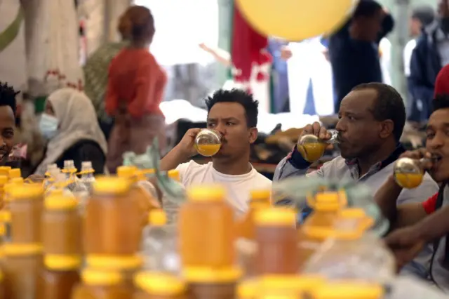 People buy Tej to drink at a market in Addis Ababa, Ethiopia.