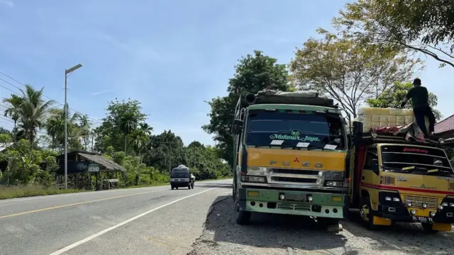 Truk-truk yang membawa bahan makanan pokok dari kota Medan untuk dibawa ke Banda Aceh, berhenti tidak jauh dari lokasi pembantaian 1965 di Simpang Betung, Sigli.