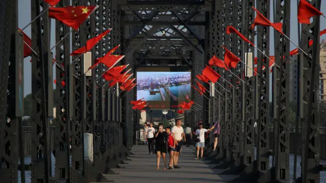 People on the Broken Bridge over the Yalu river that divides North Korea and China