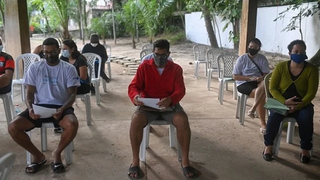 Pessoas sentadas usando máscara