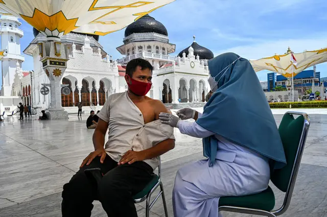 Чоловік отримує вакцину проти коронавірусу біля великої мечеті Байтуррахман в місті Банда-Ачех, Індонезія