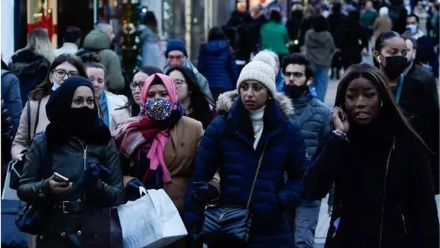 متسوقون في شارع أوكسفورد بلندن يرتدي بعضهم الكمامة.