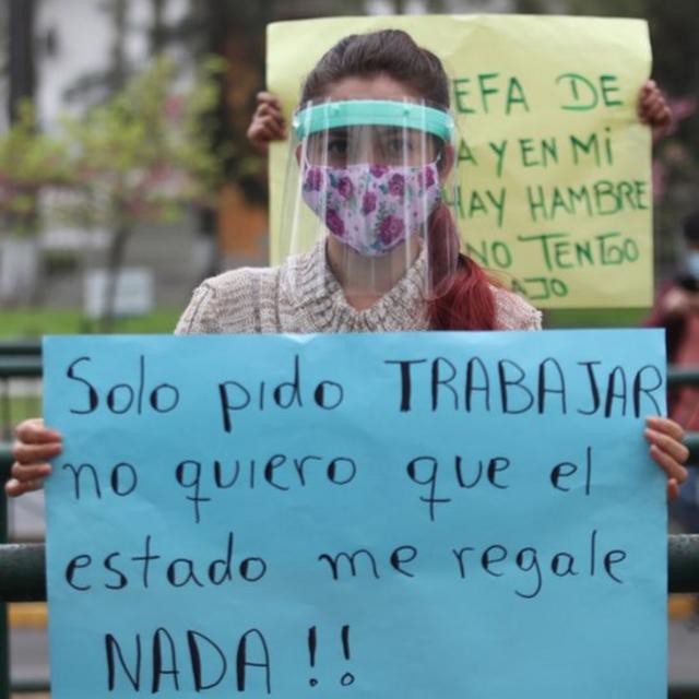 Una mujer en Perú con un letreto solicitando que le permitan trabajar.