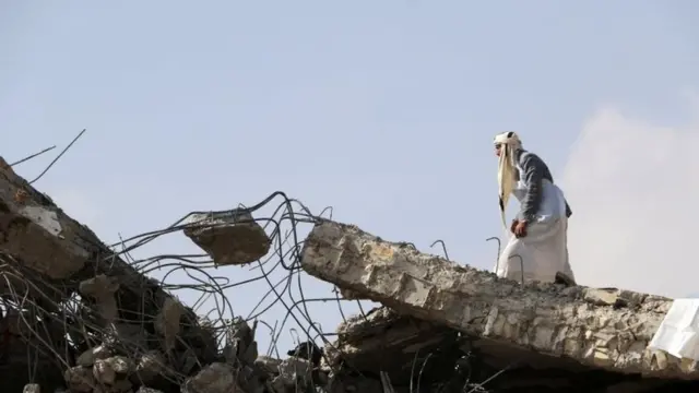 இடிபாடுகள் மீது நிற்கும் ஒரு நபர்.