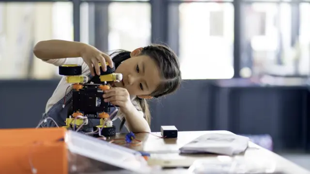 Niña construyendo un robot