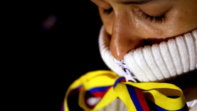 Mujer con lazo en la boca con los colores de la bandera de Colombia.