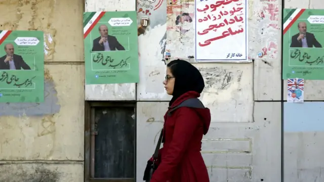 ايرانية تسير قرب ملصق