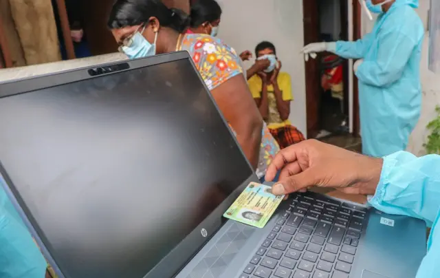 COLOMBO, SRI LANKA - 2021/08/13: Sri Lankan Army health official prepares to register a man to receive a dose of (Covid-19) coronavirus vaccine during a mobile vaccination drive by army health officials in Colombo. (Photo by Saman Abesiriwardana/Pacific Press/LightRocket via Getty Images)