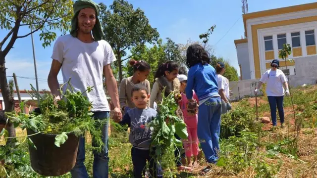 أطفال يساهمون في الزراعة في نشاط بإحدى الحدائق