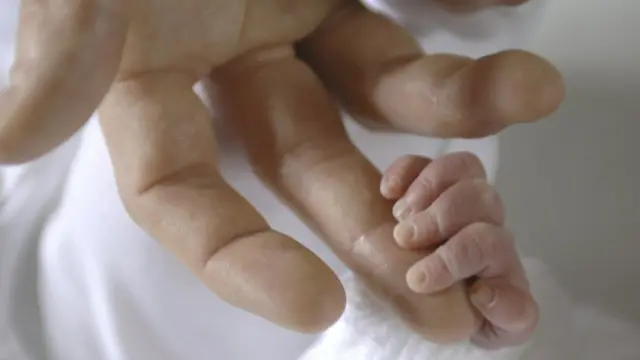 Bebé agarrando el dedo de un adulto