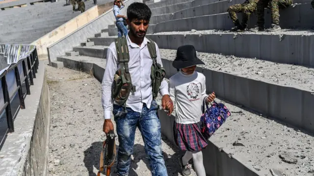 కూతురుతో వెళ్తుతున్న సిరియా సైనికుడు