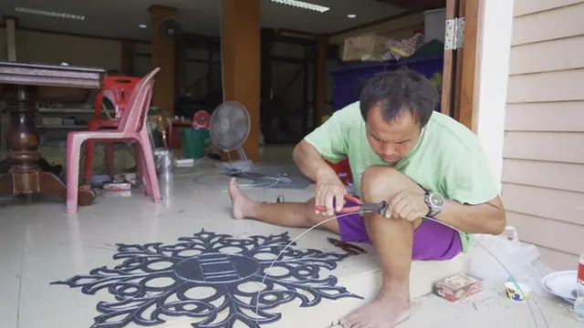 สมาชิกวงเสียงอิสานกำลังซ่อมแซมอุปกรณ์ประดับฉาก