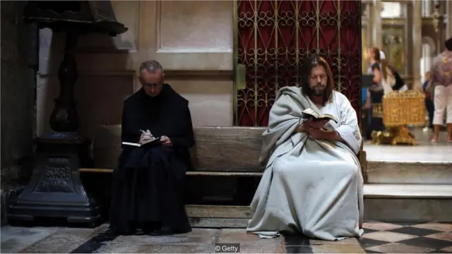 Um peregrino lê a Bíblia na Igreja do Santo Sepulcro,bet esporte comJerusalém