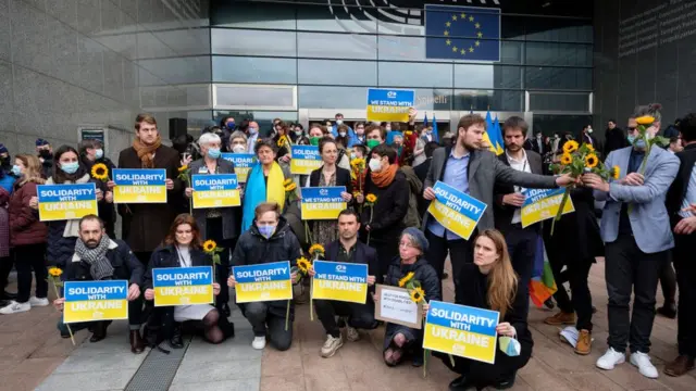 Miembros del Parlamento Europeo sostienen carteles de solidaridad con Ucrania después de una sesión plenaria extraordinaria, 1 de marzo de 2022